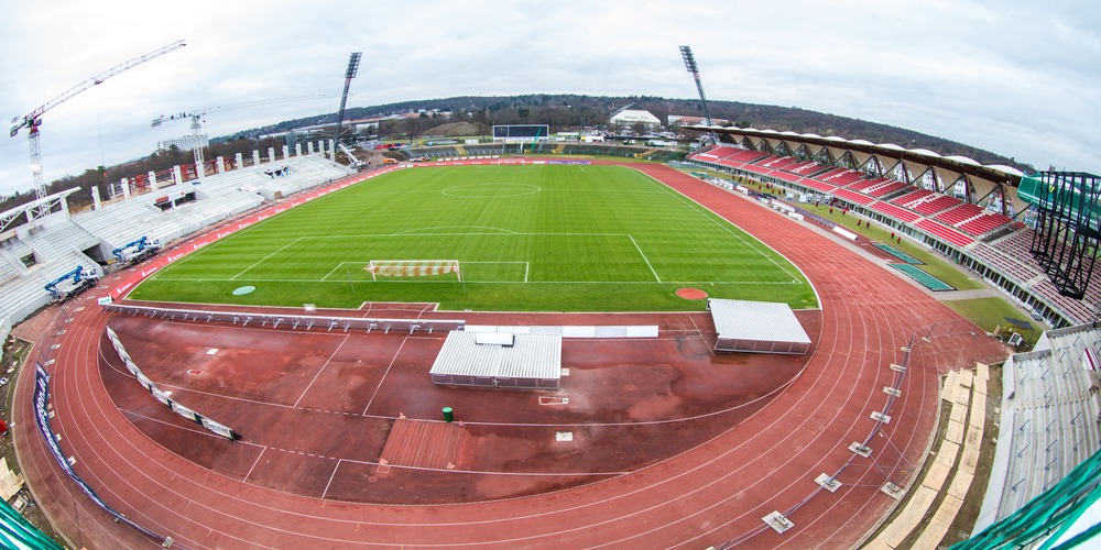 Weitwinkelaufnahme Stadioninnenraum während der Bauzeit aus dem Gästebereich Nord Richtung Haupttribüne. Die Haupttribüne befindet sich noch im Rohbau. Der Südbereich des Stadions ist noch im ursprünglichen Zustand.